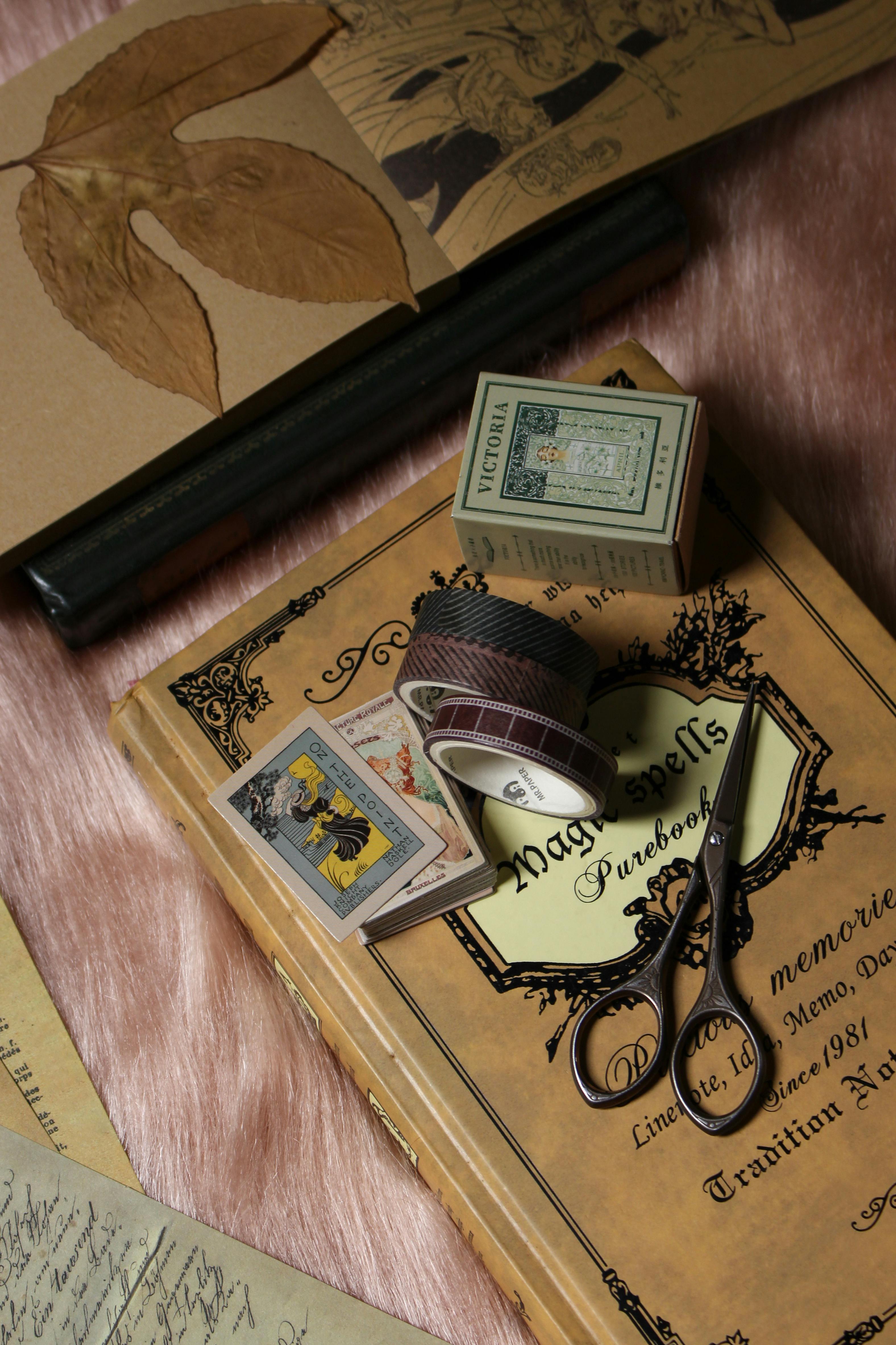 Vintage scrapbook cover with washi tape, scissors, and layered paper on a soft background